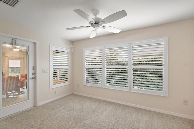 spare room with ceiling fan and light colored carpet