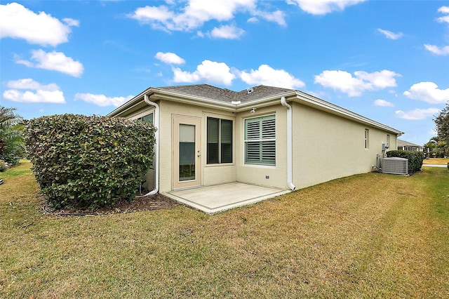 back of house with a patio, central air condition unit, and a lawn