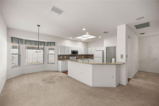 kitchen featuring white appliances, pendant lighting, white cabinetry, light carpet, and tasteful backsplash