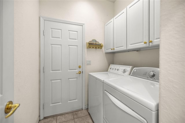 laundry area featuring cabinets, independent washer and dryer, and light tile patterned flooring