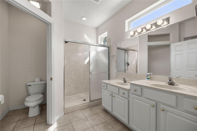 bathroom featuring tile patterned floors, toilet, a shower with door, and vanity