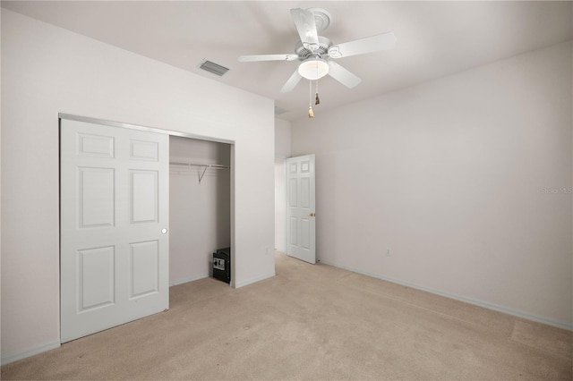 unfurnished bedroom featuring ceiling fan, a closet, and light colored carpet