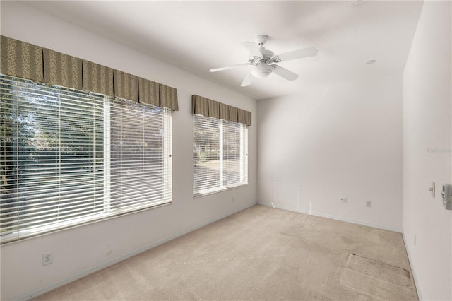 empty room with ceiling fan and light colored carpet