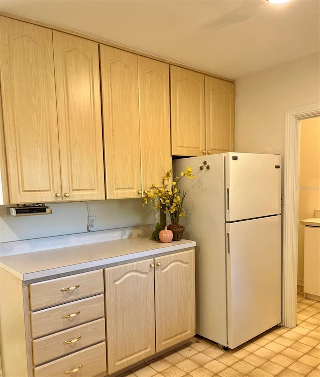 kitchen featuring light brown cabinetry and white refrigerator