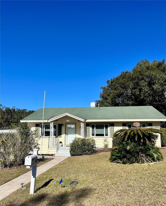 single story home featuring a front lawn