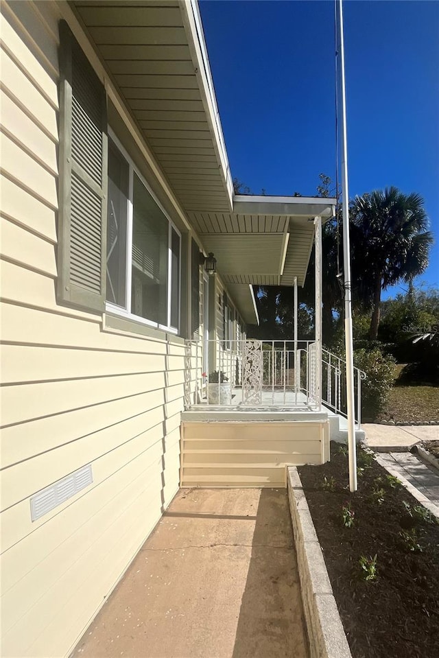 view of side of property featuring covered porch