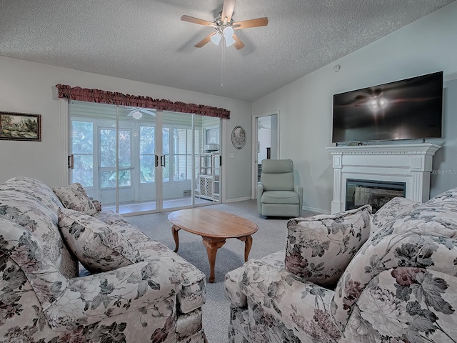 carpeted living room with ceiling fan, a textured ceiling, and vaulted ceiling