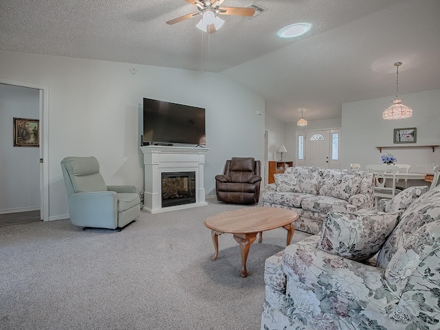 carpeted living room with a textured ceiling, vaulted ceiling, and ceiling fan