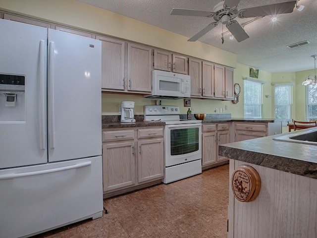 kitchen with light brown cabinets, sink, white appliances, and a textured ceiling