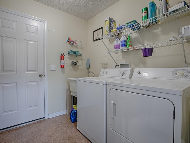 washroom with washer and clothes dryer and a textured ceiling