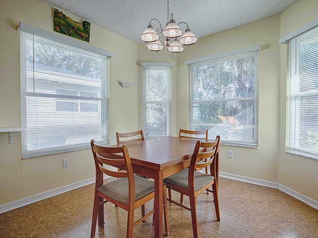 dining room featuring a chandelier, a textured ceiling, and a wealth of natural light