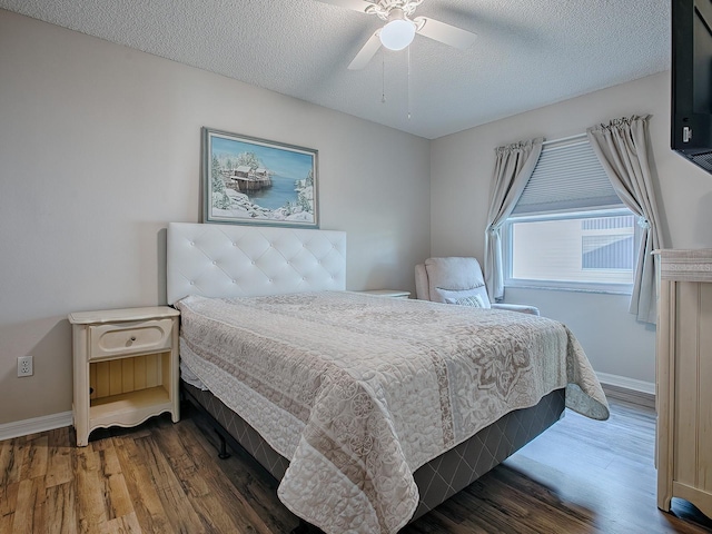bedroom featuring a textured ceiling, ceiling fan, and dark hardwood / wood-style floors