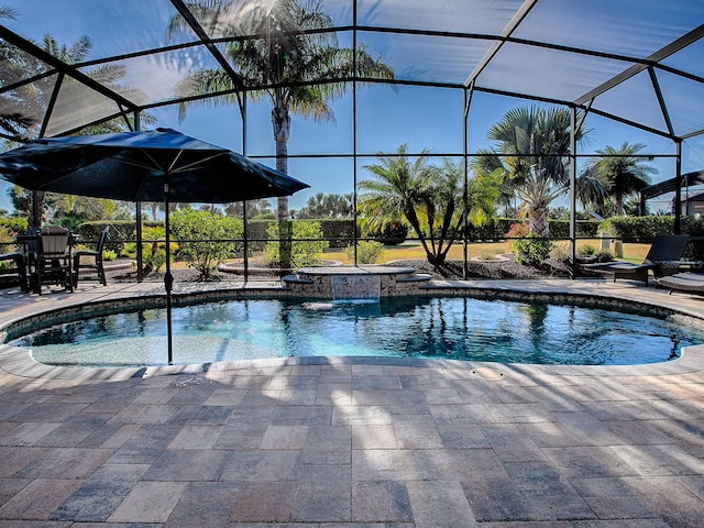 view of swimming pool featuring glass enclosure, an in ground hot tub, and a patio