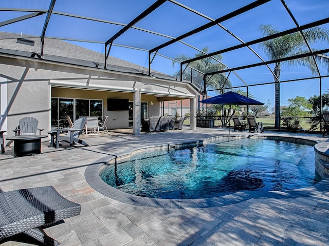 view of pool with glass enclosure and a patio area