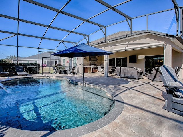 view of swimming pool featuring glass enclosure, exterior kitchen, a hot tub, pool water feature, and a patio area