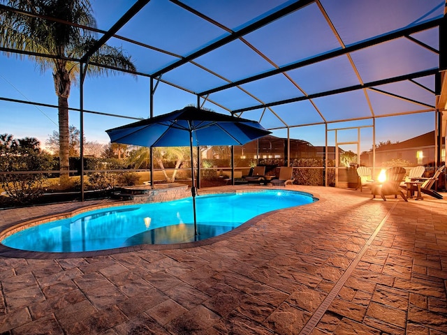 pool at dusk featuring a patio area and a lanai