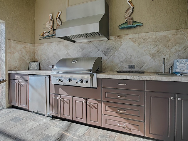 kitchen featuring refrigerator, premium range hood, tasteful backsplash, dark brown cabinets, and sink