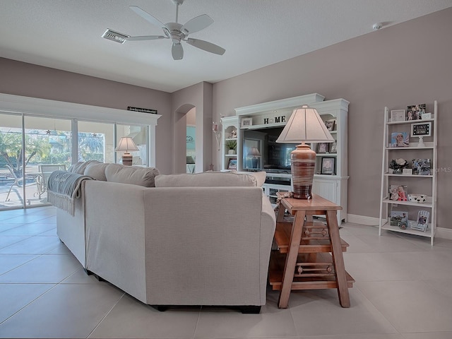 tiled living room featuring ceiling fan and a textured ceiling