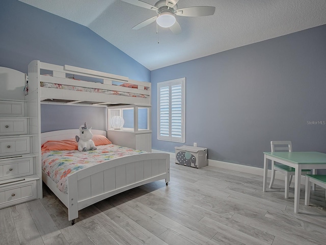 bedroom featuring a textured ceiling, ceiling fan, light hardwood / wood-style flooring, and lofted ceiling