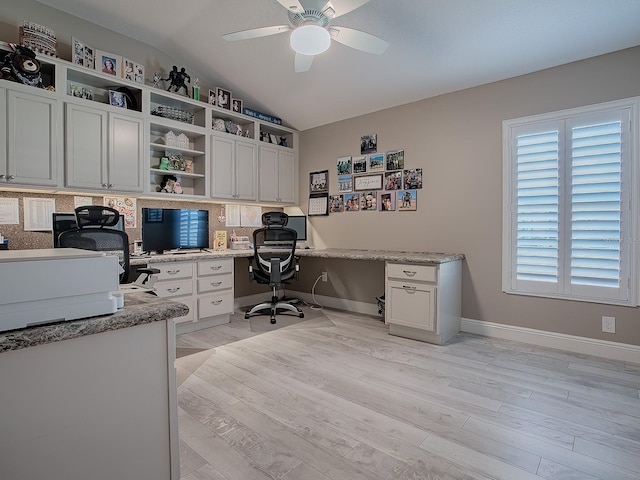 office with ceiling fan, built in desk, vaulted ceiling, and light wood-type flooring