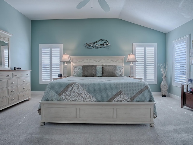 bedroom featuring ceiling fan, light colored carpet, and vaulted ceiling