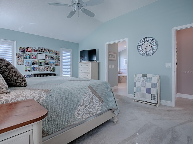 bedroom featuring ceiling fan, lofted ceiling, multiple windows, and ensuite bath