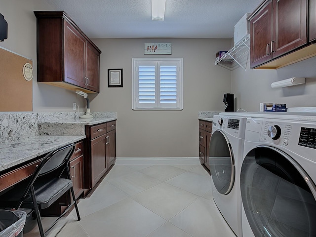 washroom featuring cabinets, light tile patterned floors, and washing machine and clothes dryer