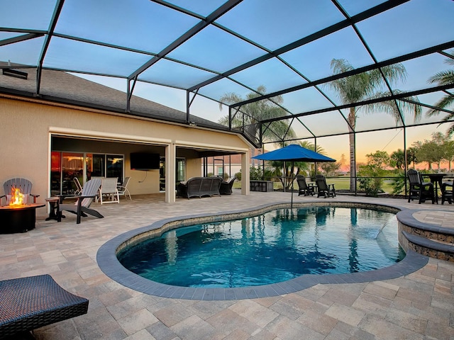 view of pool with a patio, an outdoor fire pit, and a lanai