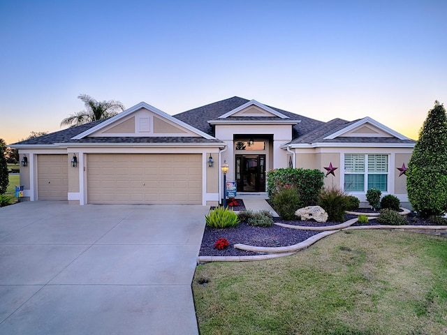 ranch-style home with a yard and a garage