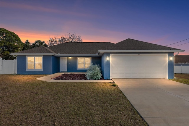 ranch-style home with a garage and a yard