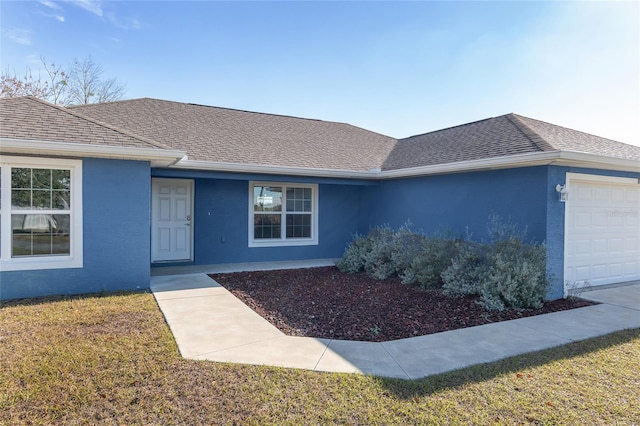 view of front of home with a front lawn and a garage