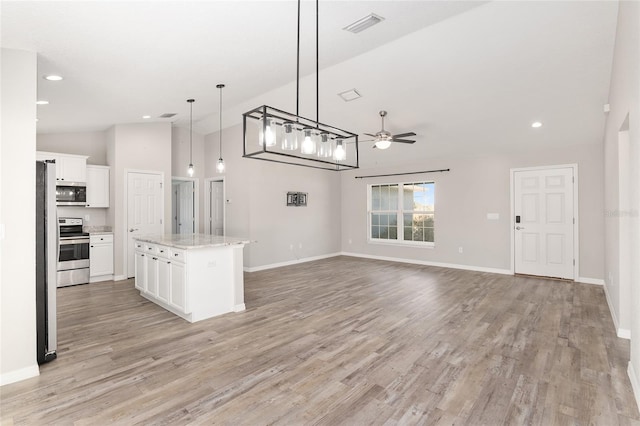 kitchen with white cabinetry, ceiling fan, stainless steel appliances, pendant lighting, and a kitchen island