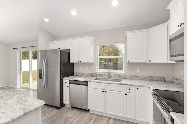 kitchen featuring appliances with stainless steel finishes, light wood-type flooring, white cabinetry, and sink