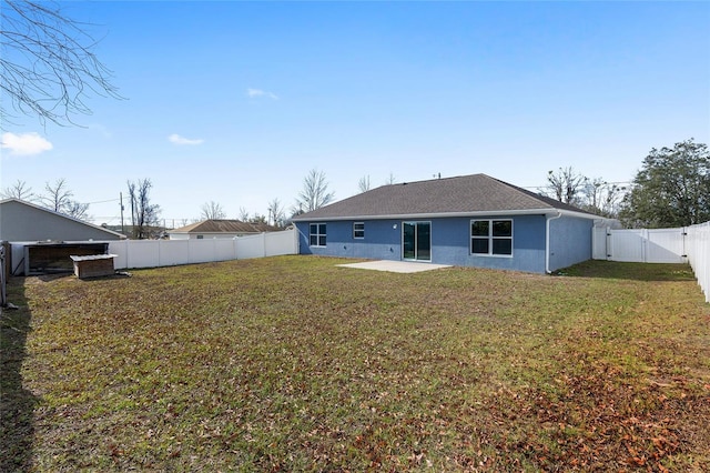 back of house with a patio area and a lawn