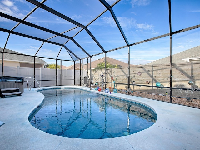 view of swimming pool with a hot tub, a patio area, and glass enclosure