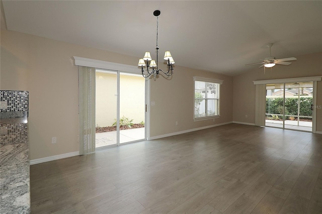 spare room featuring hardwood / wood-style floors, a healthy amount of sunlight, and ceiling fan with notable chandelier