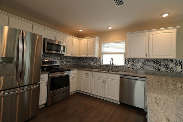 kitchen with white cabinets, light stone counters, sink, and appliances with stainless steel finishes