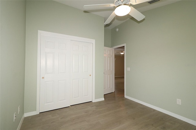 unfurnished bedroom featuring ceiling fan, a closet, and light hardwood / wood-style flooring