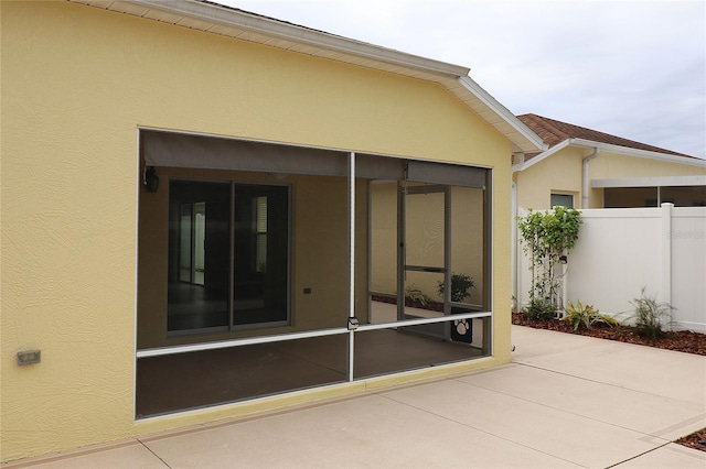 rear view of property featuring a sunroom and a patio