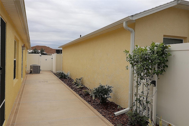 view of side of property featuring a patio area and central AC unit