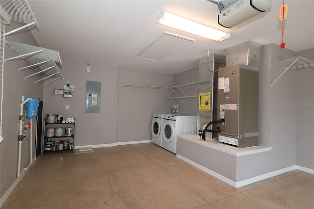 clothes washing area featuring washing machine and dryer, electric panel, and heating unit