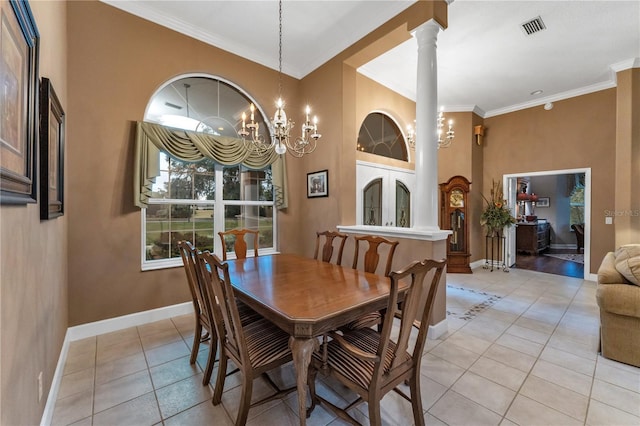 tiled dining area featuring decorative columns, ornamental molding, and a notable chandelier