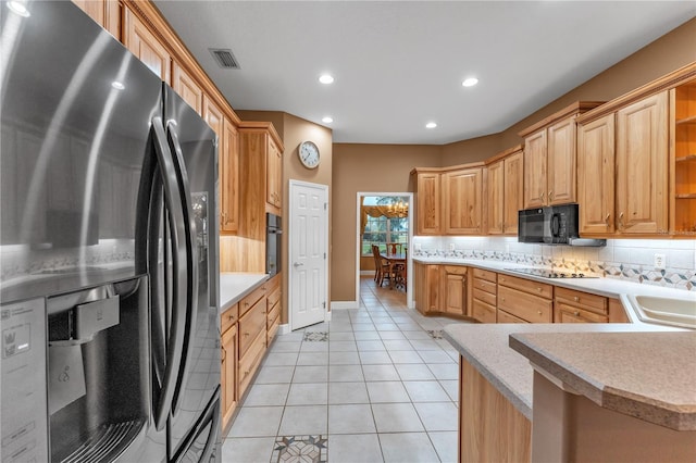 kitchen featuring light tile patterned floors, kitchen peninsula, backsplash, black appliances, and sink