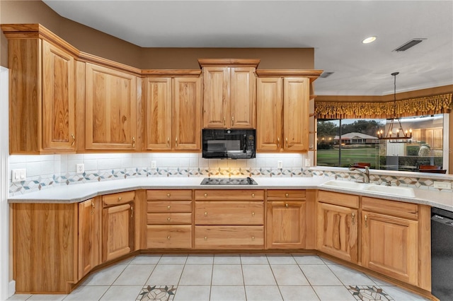 kitchen with light tile patterned floors, decorative backsplash, a notable chandelier, sink, and black appliances