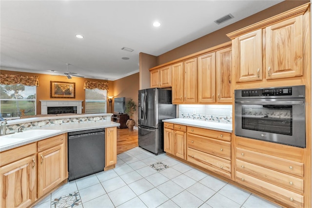 kitchen featuring light brown cabinets, stainless steel appliances, sink, backsplash, and ceiling fan