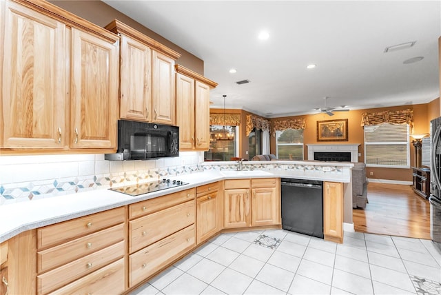 kitchen with black appliances, backsplash, light brown cabinets, and pendant lighting