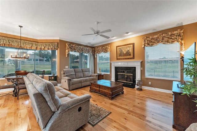 living room with plenty of natural light, wood-type flooring, crown molding, and a fireplace