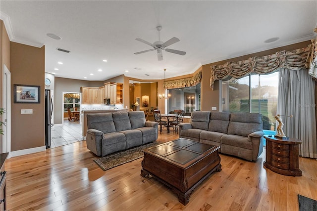 living room with crown molding, ceiling fan with notable chandelier, and light hardwood / wood-style flooring