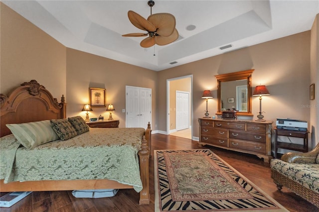 bedroom with ceiling fan, hardwood / wood-style floors, and a raised ceiling