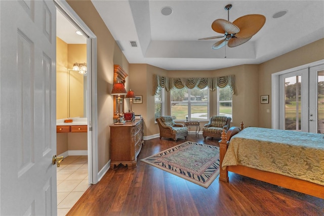 bedroom featuring ceiling fan, a raised ceiling, access to outside, wood-type flooring, and french doors